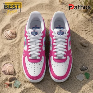Barbie x Washington Mystics Pink Nike Air Force 1 Sneakers 1 Barbie x Washington Mystics Pink Nike Air Force 1 Sneakers featuring pink and white panels resting on sandy ground.