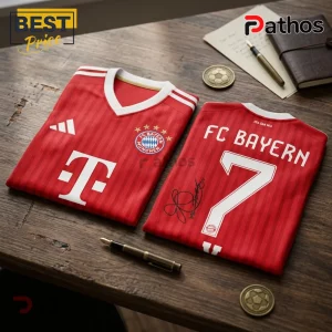 BTS x Bayern Munich V Signature Red Football Jersey 1 FC Bayern Munich red soccer jerseys on a wood desk with a T-Mobile logo, number 7, and a black ink autograph.!