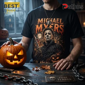 Michael Myers Evil Never Sleeps Horror Movie T-Shirt 3 Black cotton t-shirt featuring graphic of Michael Myers with a knife, orange text, and pumpkin imagery on a dark table.!