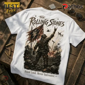 White t-shirt featuring a Rolling Stones graphic of a soldier with a rock hand gesture, flag, and battlefield scenery.!