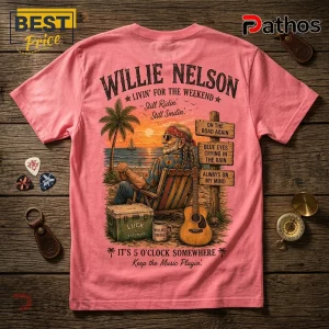 Willie Nelson Retro Sunset Pink T-Shirt 5 Pink t-shirt with Willie Nelson graphic featuring a beach scene, guitar, cooler, and song title wooden signposts.!
