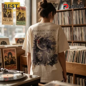 Off-white cotton t-shirt featuring a back print of a woman sitting by a moonlit stone pillar with text Starlight Dreams.!