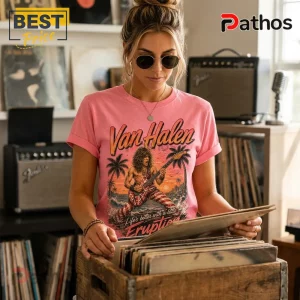 Van Halen Vintage Retro Sunset Pink T-Shirt 2 Woman wearing a pink Van Halen t-shirt with Eddie Van Halen illustration, palm trees, and ocean background in record store.!
