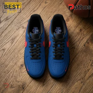 Blue Nike Air Force 1 sneakers with red swoosh accents, black laces, and Mystics logo on insoles on a wood floor.!