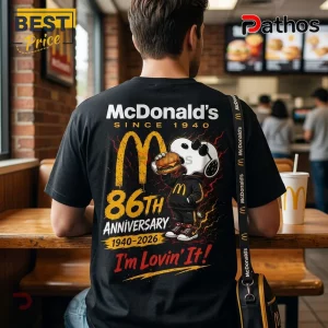 McDonalds Snoopy 86th Anniversary Black T-Shirt featuring Snoopy eating a burger and gold anniversary branding graphics.