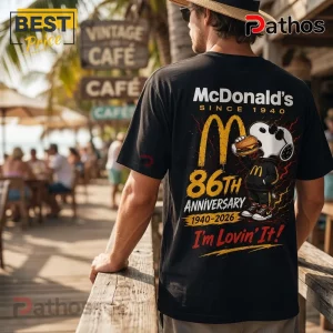 McDonalds Snoopy 86th Anniversary Black T-Shirt featuring Snoopy holding a burger, golden arches, and vintage typography.