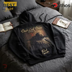 Black hoodie with Don't Look Down Rod Wave graphic print on back, laying flat on gray bedding next to open notebooks.!