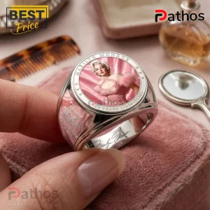 Marilyn Monroe 100th Anniversary Pink Engraved Ring featuring her portrait, metal band, and text on a velvet background.