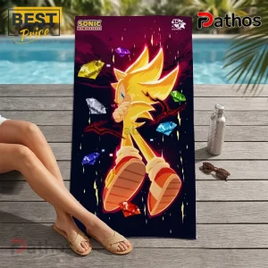 Super Sonic beach towel with yellow character and multicolored chaos emeralds on a dark purple background.!