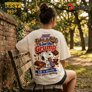 Snoopy x Snickers Snack Break T-Shirt 3 Off-white t-shirt featuring Snoopy eating a Snickers bar with text reading Take a Bite, Lose the Grump and Life is sweeter.!