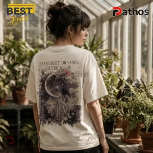 Cream-colored cotton t-shirt with back graphic showing a girl sitting under a crescent moon, reading Starlight Dreams, Silver Noise.!