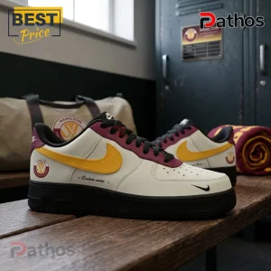 PWHL Hamilton Custom Air Force 1 Sneakers in white, maroon, and yellow sitting on a wooden bench inside a locker room.
