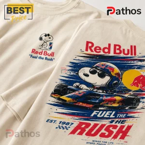 Cream colored cotton t-shirt with Snoopy racing graphic, Red Bull logos, and Fuel the Rush text in red, blue, and yellow.!
