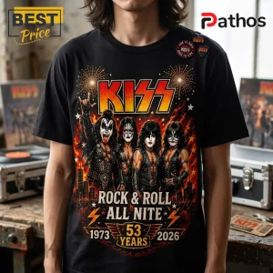 Black cotton t-shirt featuring a vintage graphic of the band KISS with flaming background, dates 1973-2026, and text.!