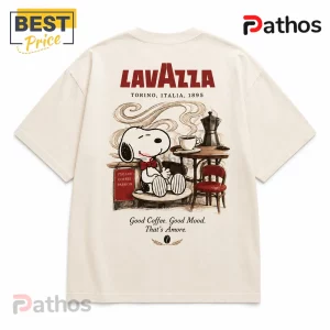 Cream-colored t-shirt featuring Snoopy drinking coffee, Lavazza branding, and the text Good Coffee. Good Mood. That's Amore.!