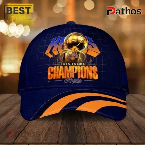 New York Knicks 2026 NBA Champions Navy Blue Baseball Cap 4 Navy blue baseball cap with Knicks 2025-26 NBA Champions graphics, gold basketball trophy, and orange curved brim accents.!