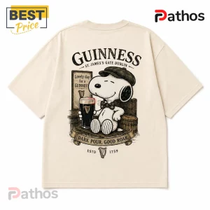 Guinness x Snoopy Vintage Cream T-Shirt 3 Beige cotton t-shirt featuring Snoopy wearing a flat cap holding a Guinness pint with text Lovely Day for a Guinness.!
