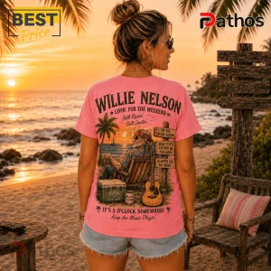 Willie Nelson Retro Sunset Pink T-Shirt 2 Pink t-shirt with Willie Nelson graphic featuring a beach scene, guitar, and song titles on a wooden signpost.!