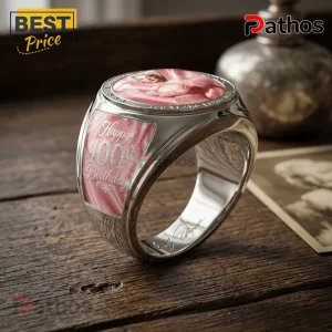 Marilyn Monroe 100th Anniversary Pink Engraved Ring with a portrait inlay and text on a rustic wooden background.